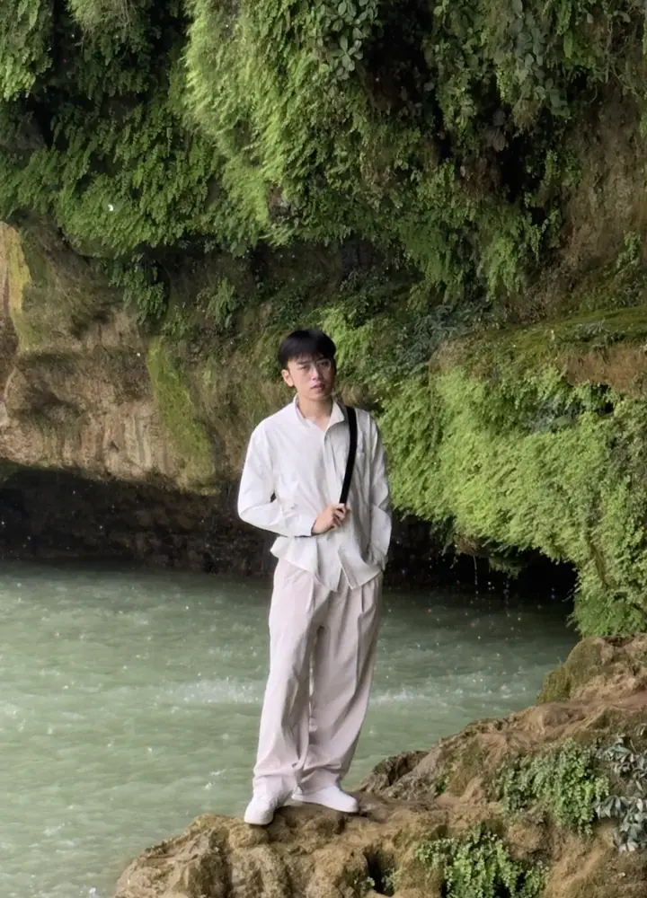 Hung standing on rocks beside green water