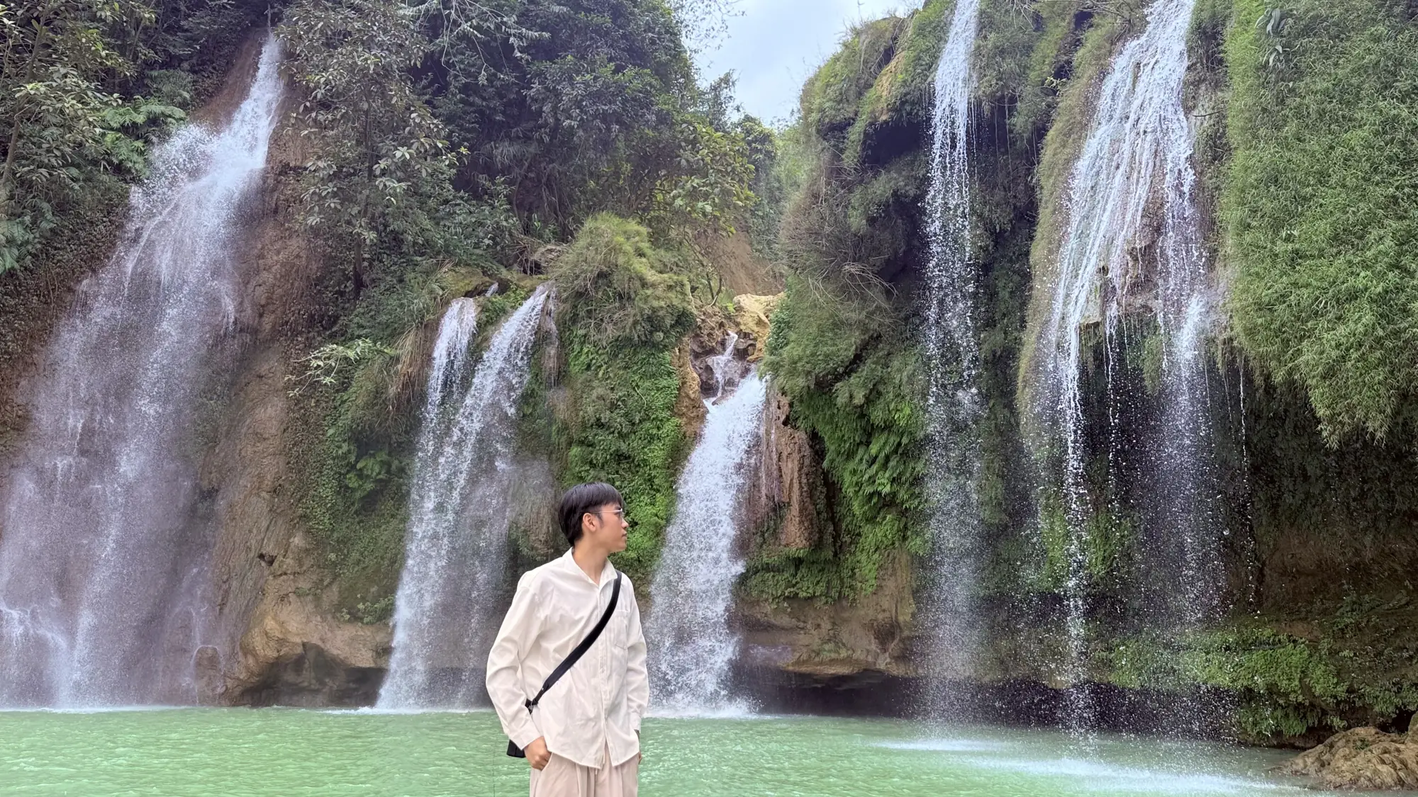 Hung standing in front of a waterfall